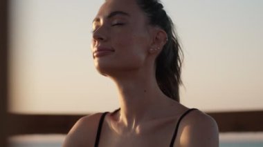 Genç ve güzel bir kadın sabah plajda meditasyon yapıyor.