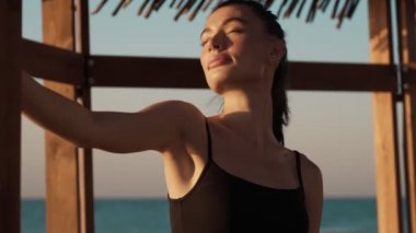 Rahatlamış genç bir kadının kırpılmış görüntüsü sabahın köründe sahildeki oyukta duruyor.