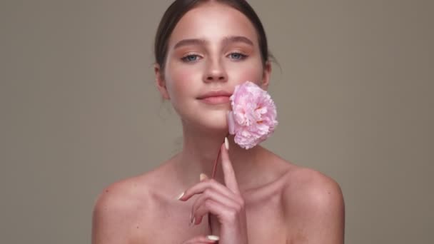 Νεαρή Καταπληκτική Γυναίκα Υγιές Δέρμα Που Ποζάρει Λουλούδι Απομονωμένο Γκρι — Αρχείο Βίντεο