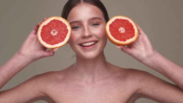 Fiatal Pozitív Egészséges Bőr Pózol Grapefruit Elszigetelt Szürke Fal Háttér — Stock videók