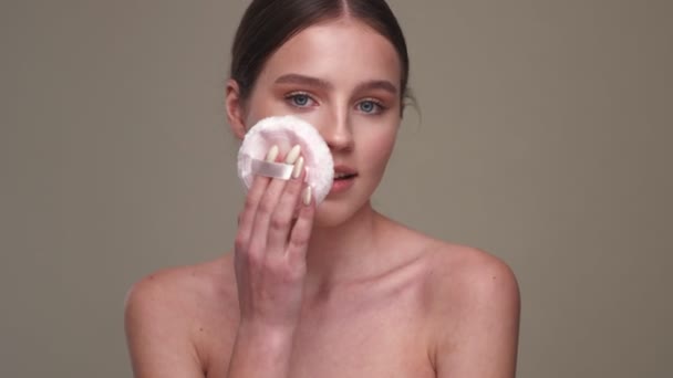 Junge Positive Mädchen Halten Make Puder Puff Isoliert Über Graue — Stockvideo