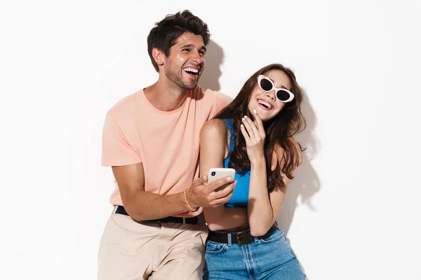 Imagen Pareja Alegre Atractiva Riendo Mientras Utiliza Teléfono Celular Aislado — Foto de Stock