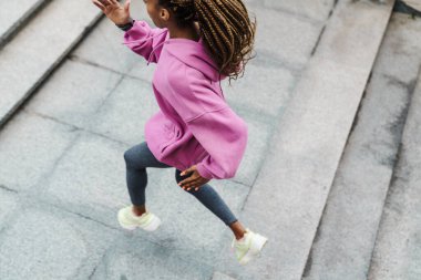 Açık havada merdivenlerde koşan formda genç bir sporcunun en iyi görüntüsü.