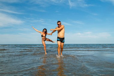 Genç aşık çift kumsalda eğleniyor.