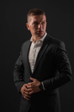 Koyu arka plan üzerinde duran genç işadamı