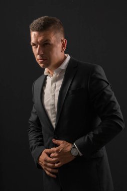 Koyu arka plan üzerinde duran genç işadamı