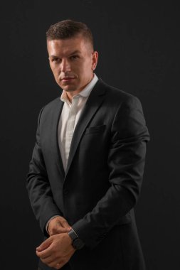 Koyu arka plan üzerinde duran genç işadamı