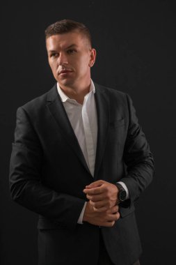 Koyu arka plan üzerinde duran genç işadamı