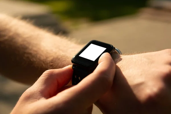 Man te klikken op een knop van zijn slimme horloge op zonsondergang — Stockfoto