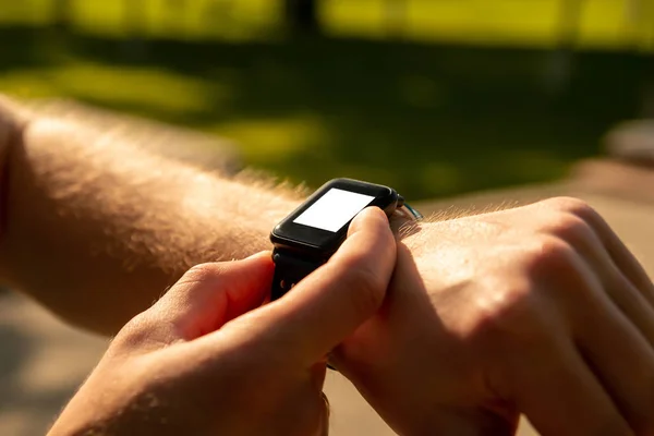 Man te klikken op een knop van zijn slimme horloge op zonsondergang — Stockfoto