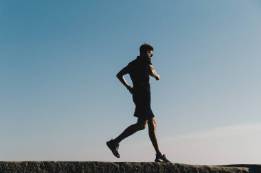 Gündoğumunda gökyüzünde koşan genç adam