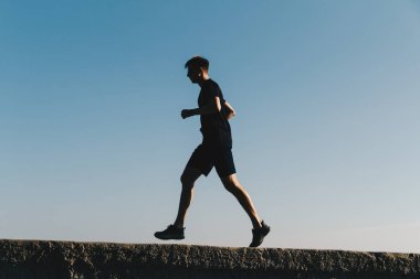 Gündoğumunda gökyüzünde koşan genç adam