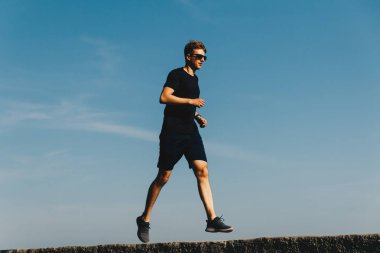 Gündoğumunda gökyüzünde koşan genç adam