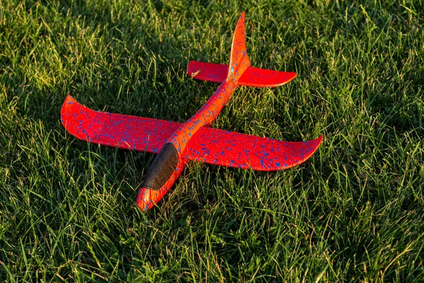 Rode Speelgoed Vliegtuig Liggend Het Gras Bij Zonsondergang — Stockfoto