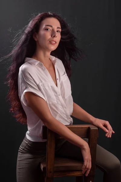 Porträtt av ung brunett flicka sitter på en stol — Stockfoto