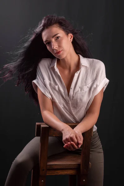 Portret młodej dziewczyny brunetka siedzi na krześle — Zdjęcie stockowe
