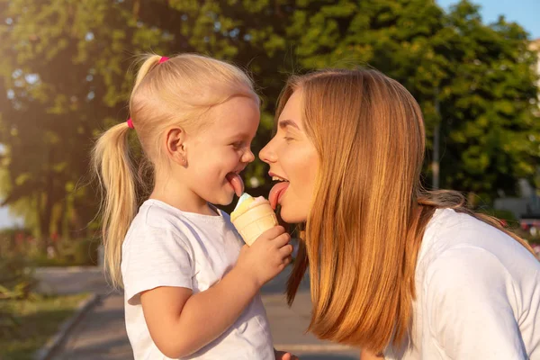 Jonge moeder en dochter eten een ijsje. — Stockfoto
