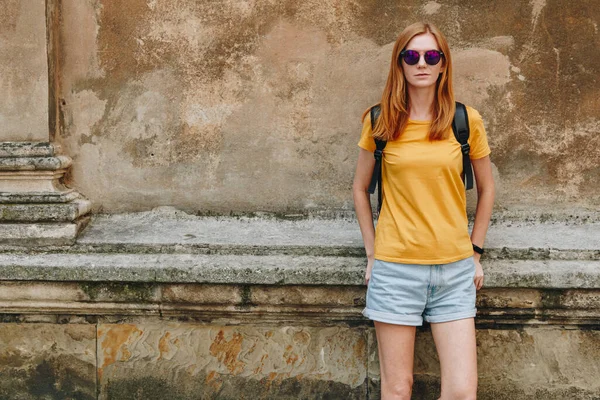 Eski duvardaki genç kızıl saçlı kadın.