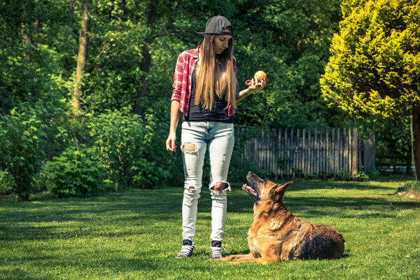 Authentic casual woman teaching dog obedience.