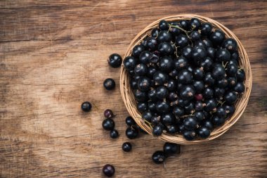 Taze olgun blackcurrant sepeti, ahşap tahta üzerinde kopya alanı.