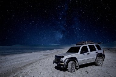 Samanyolu gece gökyüzü altında sahilde yol araba