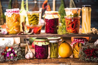Pickled Marinated Fermented vegetables on shelves in cellar clipart