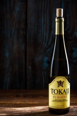 Tarnow, Polonya - 24 Eylül 2018: Macar beyaz şarap Tokaji Furmint, ahşap arka plan tek şişe.