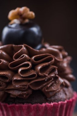 Cupcake koyu çikolata ile ceviz ile dekore edilmiştir..