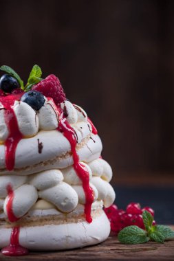 Pavlova tatlı kopya alanı ile ahşap arka plan üzerinde.
