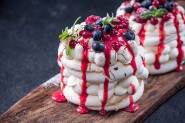 Pavlova taze berry meyve, nane ve çilek sosu ile.