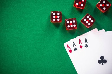 Dört poker kartları ve casino masada kırmızı dices aslar.