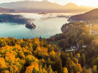 Sisli ve puslu güneş doğarken Bled Gölü'sonbahar, Slovenya.