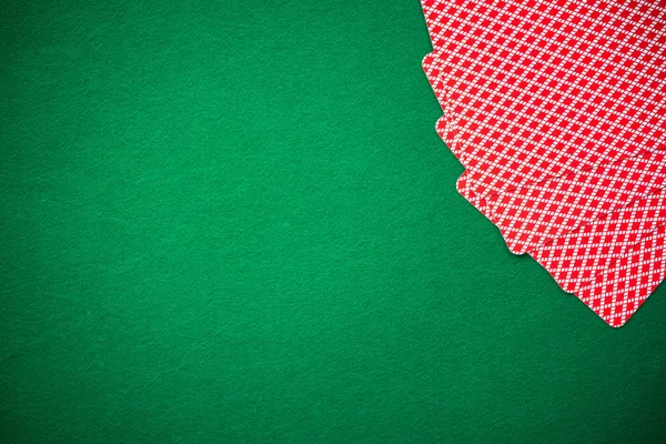 Four poker cards on green felt, copy space with spotlight.