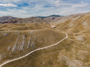 Bozulmamış tepeler ve bozkır Bosna'da kırsal yolda. Hava dron görünümü