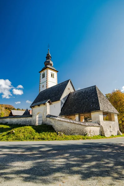 Gotik Kilisesi St John the Baptist ve taş köprü Ribcev Laz, göl Bohijn, Slovenya.