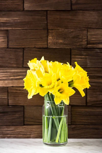 Spring yellow Daffodils flowers in vase, on wooden background — Stock Photo, Image