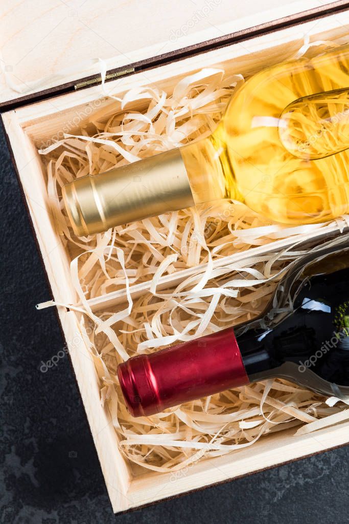 Red and white wine bottles in vintage wooden box