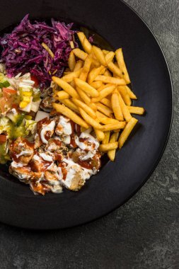 Tabakta patates kızartması ve salata ile Türk donner kebap