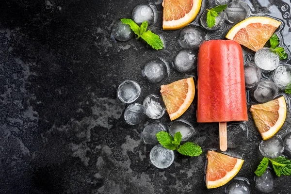 Czerwony sok pomarańczowy domowej roboty Popsicle nad lodem — Zdjęcie stockowe