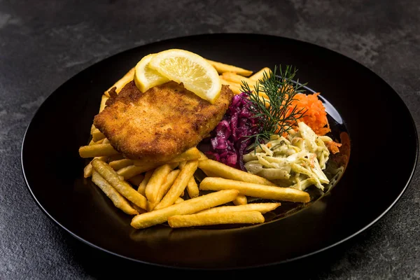 Pan fried fish with french fries and salad