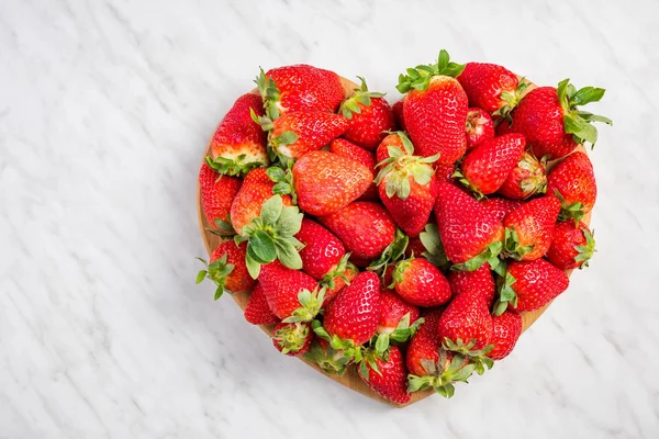 Hjärta form jordgubbar på vit marmor, kärlek till färsk frukt — Stockfoto