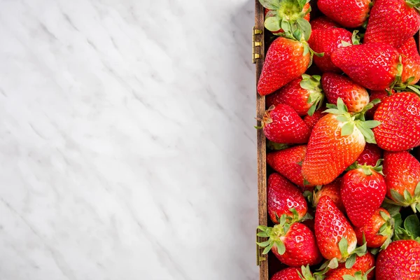 Fresas en caja de madera, fondo de mármol de borde —  Fotos de Stock