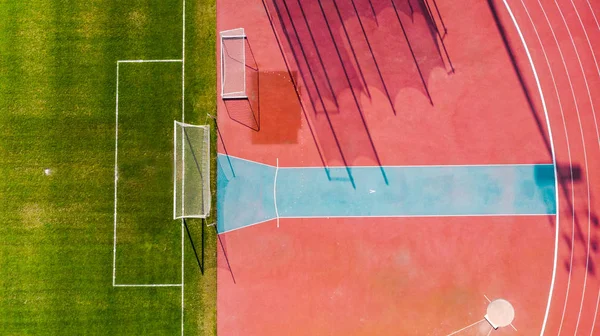 陸上競技場とサッカー場のピッチ、空中トップダウンビュー — ストック写真