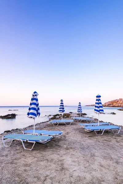 Letti solari colorati a Wild SEcret Beach all'alba a Rodi, Gre — Foto Stock