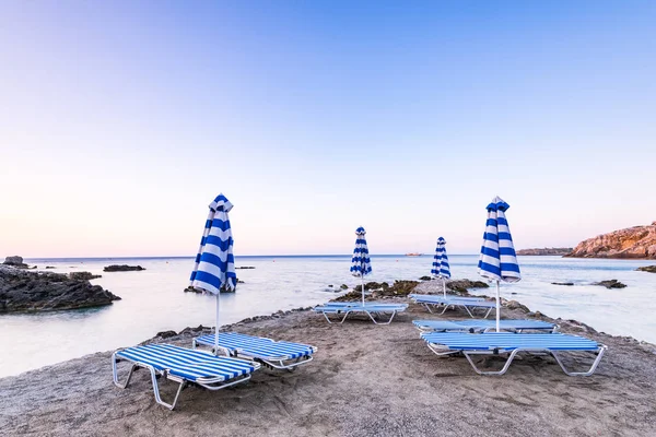 Bunte Sonnenliegen am wilden geheimen Strand bei Sonnenaufgang in Rhodos, gre — Stockfoto