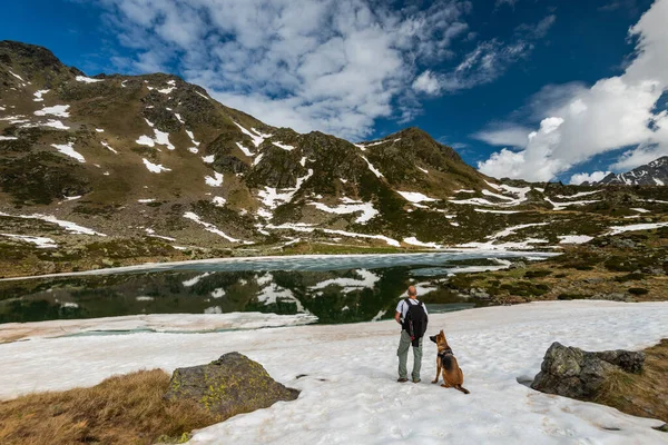 Adventure Couple Man and Dog Trekking Outdoors in High Andorra Alps Mounitains.
