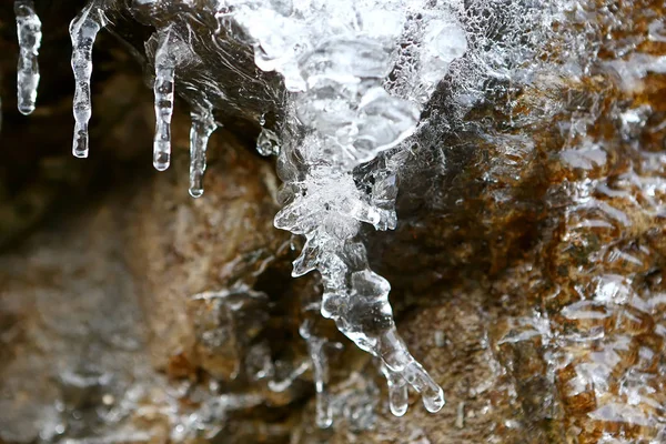 Bir taşa çözdürme buz sarkıtları Fransa dağlarda kışın duvar.