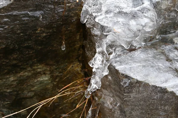 融解のつららを流れ落ちる水と人間の頭の部分に似ているが冬のフランスの山のドロップします — ストック写真