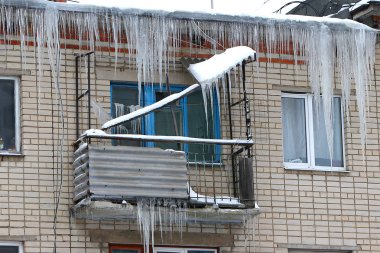 Hangi aşağı çatı Rusya'da asılı buz sarkıtları