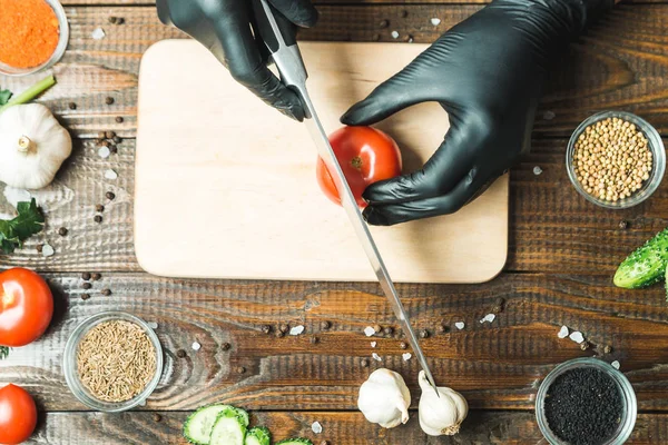 kadınların elleri kesilmiş yalan biber yanındaki bir domates, otlar, salatalık ve baharatlar